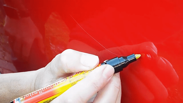 person uses CarScratcher Pencil on red car