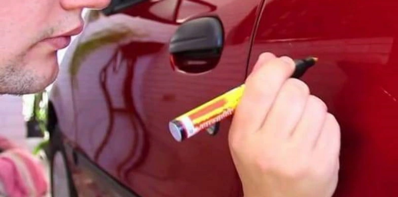 person uses CarScratcher Pencil on red car