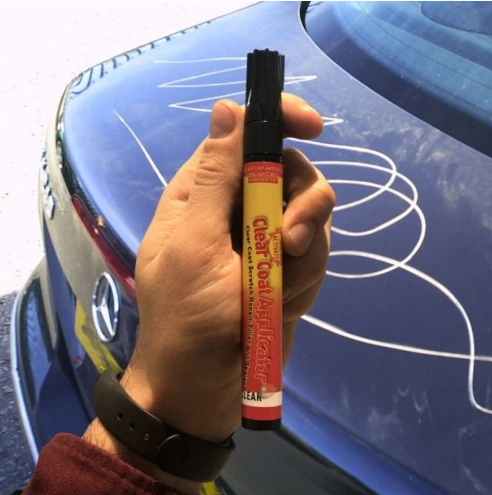 guy holds CarScratcher Pencil in front of car